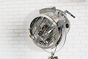 Metal projector on white brick wall