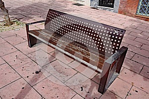 A metal public seat with a square grid pattern in a public plaza in Estepona in Spain