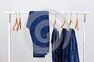 Metal rack with wooden clothes hangers and blue jeans