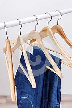 Metal rack with wooden clothes hangers and blue jeans
