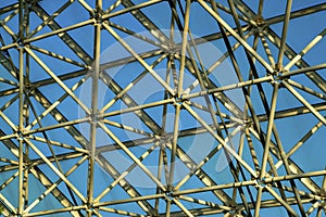 Metal rafters and scaffolding inside of building or greenhouse indoors with white metal beams and glass windows