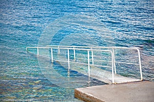 Metal railing on the pier in the sea