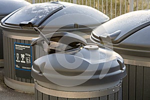 Metal recycling container filled with sorted metal waste. A metal pan sticks out of the bin, showing the process of waste sorting