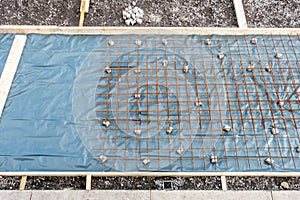 Metal reinforcement grid and wood frame for reinforced concrete basement construction