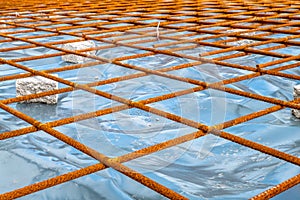 Metal reinforcement grid and wood frame for reinforced concrete basement construction