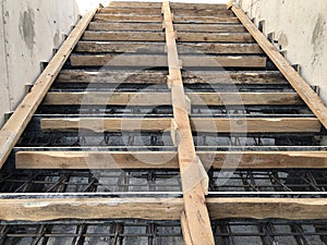 Metal reinforcement and wooden formworks of concrete stairway under construction photo