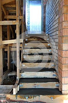 Metal reinforcement and wooden formworks of concrete stairway under construction. Stairs on the construction of the new building.