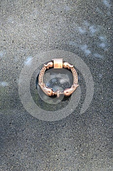 Metal ring on grave of cemetery. Rusty iron handle on granite tomb cover. An 19th century antique cemetery in Lvi
