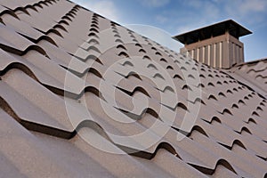 Metal Roof Construction Against Blue Sky. Roofing materials. Metal House roof. Closeup House Construction Building Materials.