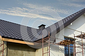 Metal roof construction with coaxial chimney pipe heating system against blue sky