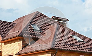 Metal roof with modern house attic construction with roof guttering and attic skylight window. Attic skylights.