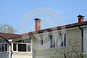 Metal roofing construction. House with a big windows. Rain gutter. Chimney coaxial. House with individual heating.