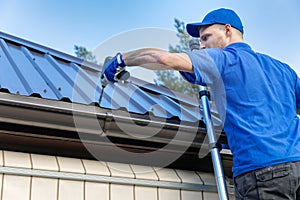 Metal roofing - roofer working on the house roof