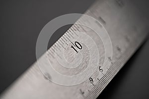 Metal ruler on a black leather  background with black numbers and scale. Show scale in black digit