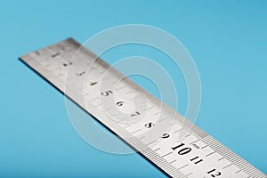 Metal ruler on a blue background close-up with a copy of the space for your text