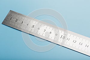 Metal ruler on a blue background close-up with a copy of the space for your text