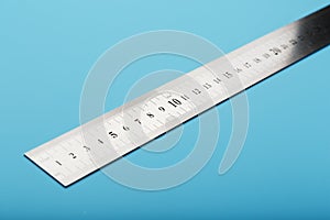 A metal ruler with a scale on a blue background is a superscape with a copy of the space for your text