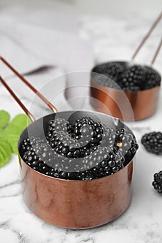 Metal saucepans with ripe blackberries