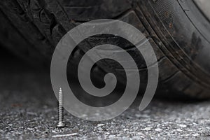 Metal screw nail on road nearly to puncture into wheel tire