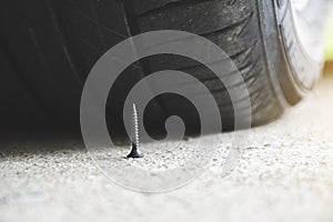 Metal screw on road nearly to puncture a car tire