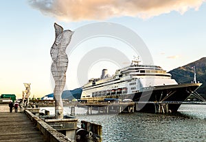 Metal sculptures on dock with cruise ships, late afternoon. Juneau, Alaska, USA.