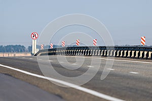 A metal separator of directions on an asphalt road between cities. Road safety