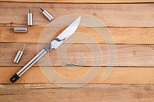 Metal set for cutting meat and grilling on wooden background
