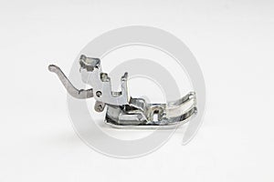 Metal sewing machine foot isolated on a white background.  Side view