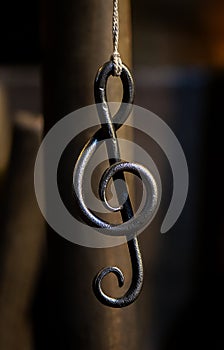 A metal sheet music key hangs in a rope in a blacksmith`s workshop