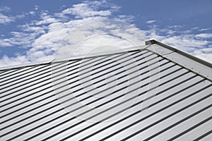 Metal sheet roof and slope with clouds and blue sky