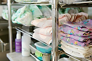 metal shelf with cloth diapers and baby lotion
