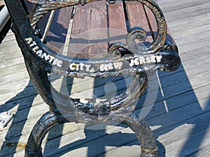 The metal side of a boardwalk bench that says Atlantic City, New Jersey