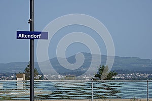 Metal signpost with a blue shield saying name of village Altendorf in Switzerland.