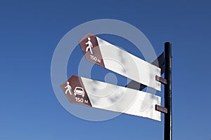 Metal signs indicating the direction against blue sky