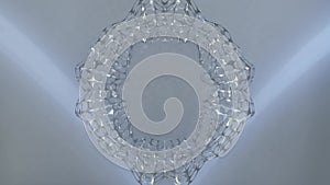 Metal silver abstract object with network structure morphing its shape on a silvery background. Shiny object of circular