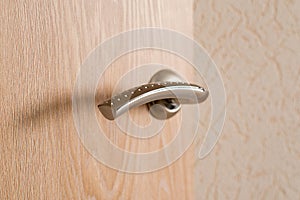 A metal silver door handle close up