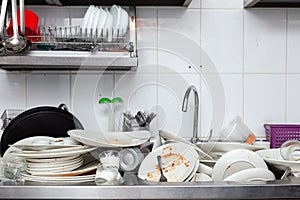 Metal sink full of dirty dishes, crockery, tableware