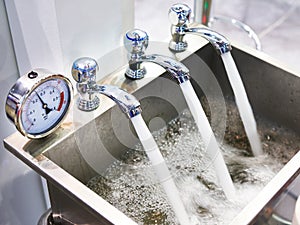 Metal sink with taps and manometer