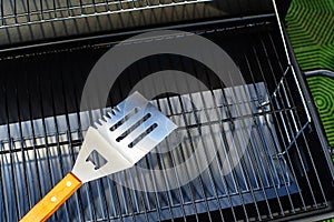 Metal spatula and grill grate. Equipment for cooking food on fire and charcoal. Close-up