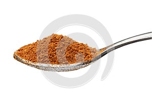 Metal spoon with ground hot chili powder close up on white background