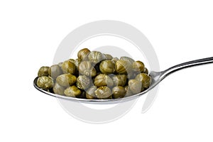 Metal spoon with marinated capers close up on white background