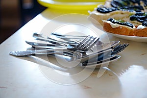 Metal spoons and forks in a pile on the table