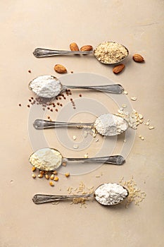 Metal spoons of various gluten free flour almond flour, oatmeal flour, buckwheat flour, rice flour, corn flour , flat