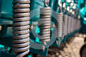 Metal springs standing in a row on the soil-processing unit