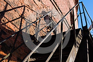 Metal staircase with brick wall