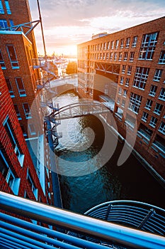 Metal staircase, bridge over canal and red brick buildings in the old warehouse district Speicherstadt in Hamburg in