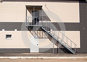 A metal staircase leading to the second floor along the outer wall of the building. fire escape