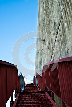 Metal stairs on the gray concrete wall