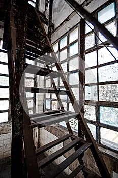 Metal stairs in an old building with dirty windows