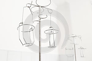 Metal stand for droppers, intravenous infusions. White background, hospital interior